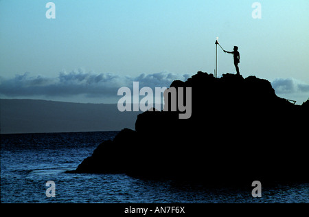 Illuminazione a torcia al tramonto sulla roccia nera, Kaanapali Beach, Maui, Hawaii Foto Stock