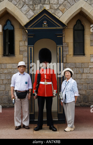 Turisti giapponesi Castello di Windsor in posa per la fotografia con soldato in servizio nella scatola di sentinelle Berkshire Inghilterra anni '2006 2000 Regno Unito HOMER SYKES Foto Stock