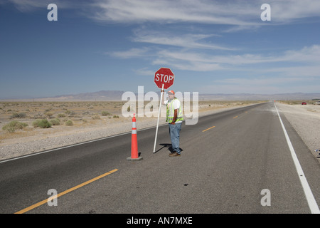 Vista del deserto del Nevada USA con l uomo e segno di stop lavori stradali Foto Stock