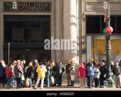 Gli acquirenti di vacanza al di fuori di Marshall Fields membro Street negozio Chicago Illinois Foto Stock