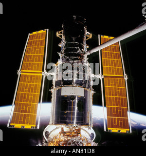 Telescopio Spaziale Hubble HST backdropped contro un orizzonte scena mentre nell'afferrare dello Space Shuttle Columbias braccio robotico Foto Stock