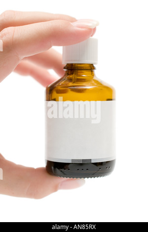 Femmina di mano che regge una piccola bottiglia di medicina. Etichetta vuota. Isolato su uno sfondo bianco. Foto Stock