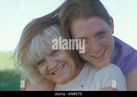 Ritratto di 57 anno vecchia donna caucasica con 22 enne figlia gioca con la sovrapposizione di capelli le loro teste Foto Stock