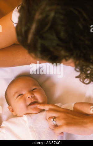 26 anno di età mista madre ispanica toccando il mento del suo '6 settimana" vecchio misti figlia ispanica Foto Stock