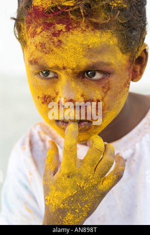 Giovane ragazzo indiano coperto di polvere colorata pigmento Foto Stock