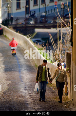 COIMBRA PORTOGALLO Coppia giovane passeggiata mano nella mano sulle strette di ciottoli lapidato street Foto Stock