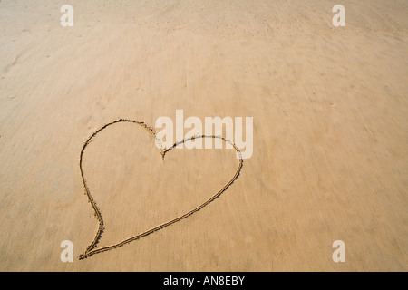 Cuore disegnato nella spiaggia di Liscia sabbia Foto Stock
