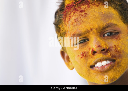 Giovane ragazzo indiano coperto di polvere colorata pigmento Foto Stock