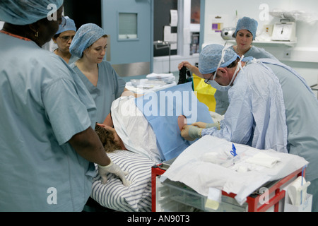 Una donna riceve un'iniezione nella colonna vertebrale in teatro prima nascita assistita Foto Stock