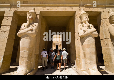 Egitto statue Hatshepsut nella forma di Osiride con doppia corona barba faraonico crook e protezione correggiato ingresso con turisti Foto Stock