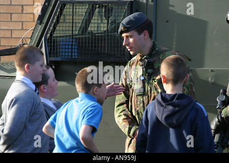 Esercito britannico RAF del reggimento di soldati parlare a locale belfast boys durante i cuori e le menti della campagna durante il tour della North Parade Foto Stock