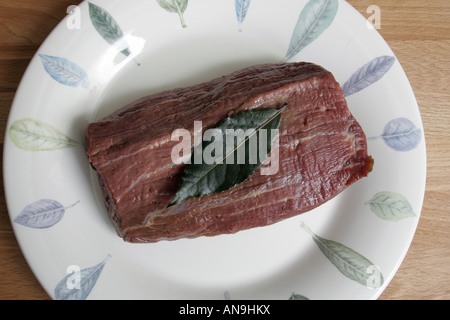 Una porzione di carne di manzo crudo su una piastra. Foto Stock