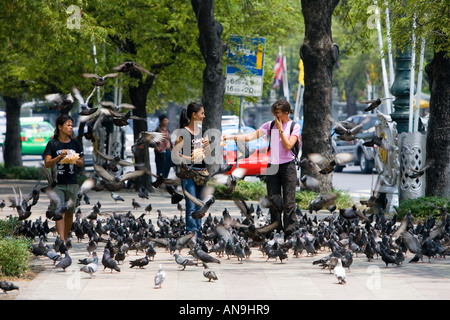 Le donne a vendere sacchi di sementi di uccelli ai turisti per le strade di Bangkok in Thailandia Foto Stock