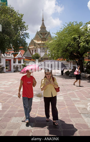 Thai donna e suo figlio presso il Tempio del Buddha Reclinato, Wat Pho (Wat Phra Chetuphon), Bangkok, Thailandia. Foto Stock