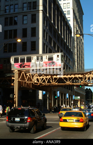 Un treno sul loop Linea ferroviaria Monroe Street con auto e taxi in Chicago Illinois USA Foto Stock