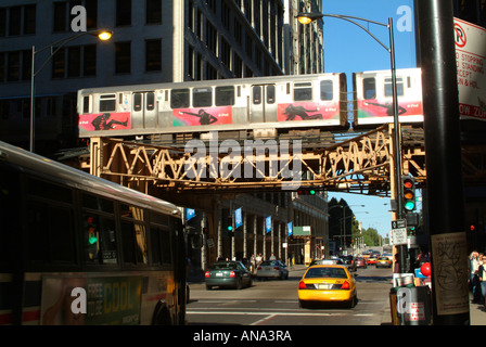 Un treno sul loop Linea ferroviaria Monroe Street con autobus e taxi in Chicago Illinois USA Foto Stock