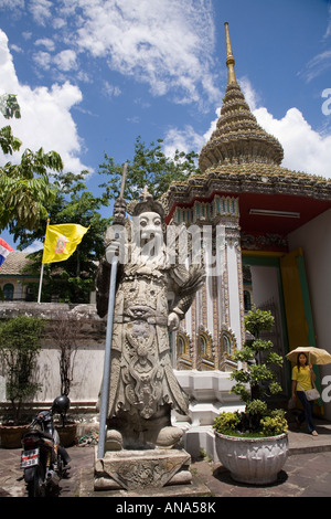 Il gigante custode presso il cancello di Wat Pho (il Tempio del Buddha Reclinato) Wat Phra Chetuphon Bangkok, Thailandia, & Re Tailandese bandiera. Foto Stock