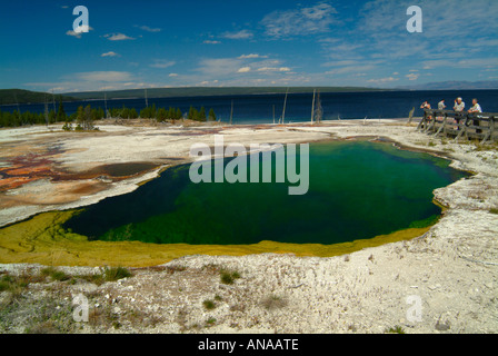 Abisso Piscina primavera calda con Lago Yellowstone in background a West Thumb Geyser Basin Parco Nazionale di Yellowstone Wyoming USA Foto Stock