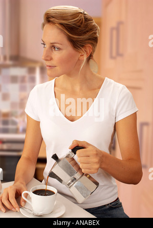 La donna in cucina il caffè di colata Foto Stock