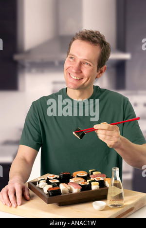 L'uomo mangiare sushi Foto Stock