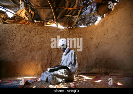 Rifugiato sudanese lettura nel suo corano Foto Stock