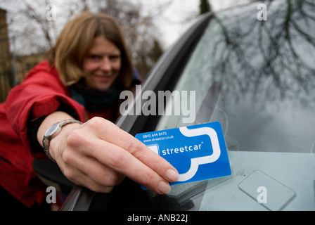 Donna che utilizza smart card per accedere a StreetCar auto a noleggio Foto Stock