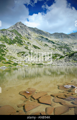 Il lago glaciale Prevalski con picco Polezan in background al parco nazionale di Pirin Foto Stock