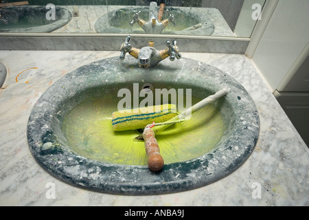 Un lavandino del bagno reso sporco dal rullo di opere di pittura. Evier de la salle de bain sali par des travaux de peinture. Foto Stock