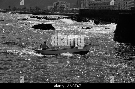 Due uomini in una piccola barca da pesca con motore fuoribordo in mare vicino a Puerto De La Cruz a Tenerife Foto Stock