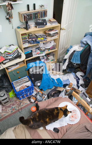 Un maschio di adolescenti camera da letto in un pasticcio con i vestiti e la spazzatura giacente ovunque Foto Stock