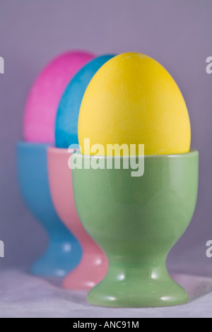Tre uova di Pasqua in coppe di uovo allineato Foto Stock
