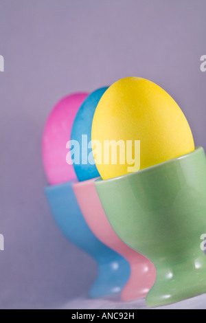 Tre uova di Pasqua in coppe di uovo allineato Foto Stock