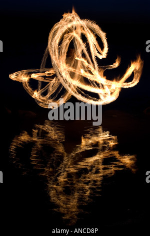 Uomo fuoco danza su una roccia in un lago in India Foto Stock