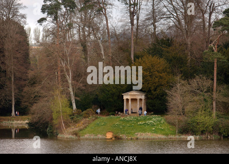 I visitatori del parco di BOWOOD HOUSE esplorare il tempio dorico che si trova accanto al lago di WILTSHIRE REGNO UNITO Foto Stock