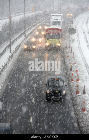 Il traffico fra auto taxi e autocarri percorrendo l autostrada M2 al di fuori di Belfast durante una forte tempesta di neve Foto Stock