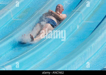 Senior uomo caucasico watersliding nell'Aqualand Water Park. L'isola di Corfù, Grecia. Foto Stock