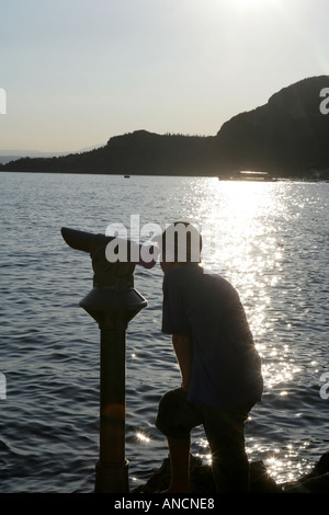 Adolescente cercando telescopio passante - Lago di Garda - Garda Trentino Foto Stock