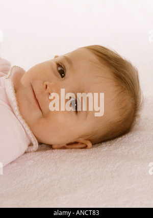 Happy Baby girl sdraiato sulla schiena sorridente Foto Stock