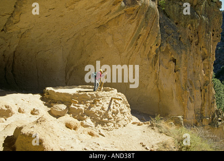 Un escursionista salite in un antico Anasazi kiva o camera di religiosi nella grotta di cerimoniale in Bendelier Foto Stock