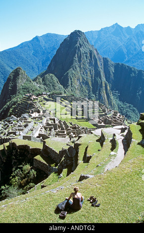 Machu Picchu rovine Inca, terrazze, turistico seduti sulla terrazza e Huayna Picchu, Perù Foto Stock