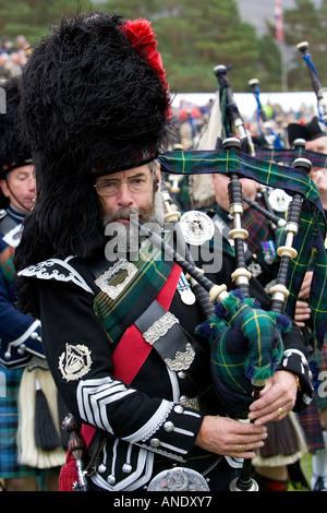 Lettore delle cornamuse di esibizione in massa di Scottish pipers a Braemar Giochi Highland Gathering Scozia Foto Stock
