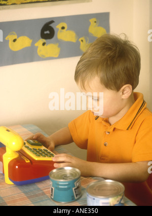 Giovane ragazzo giocando a fare la spesa utilizzando un giocattolo fino a Foto Stock