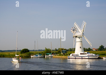 Barche a vela e crociere sul fiume passare il mulino a vento su Norfolk Broads Regno Unito Foto Stock