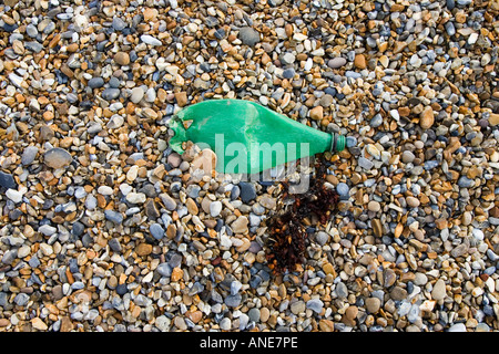 La bottiglia di plastica gettati accanto alle alghe marine sulla spiaggia Cley Norfolk Regno Unito Foto Stock