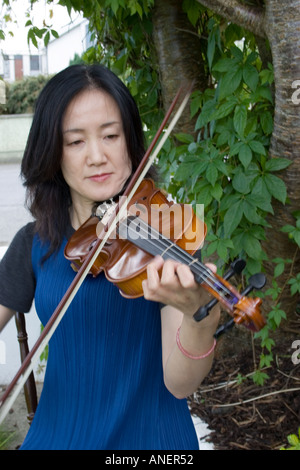 Le donne giapponesi suona il violino al di fuori Foto Stock