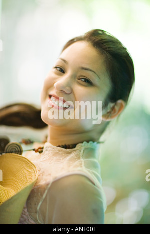 Giovane donna sorridente in telecamera, ritratto Foto Stock