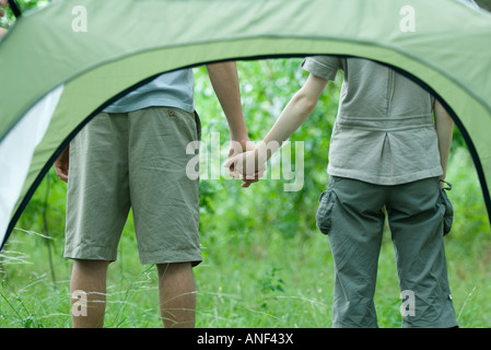 Coppia giovane Holding Hands, visto attraverso la tenda Foto Stock