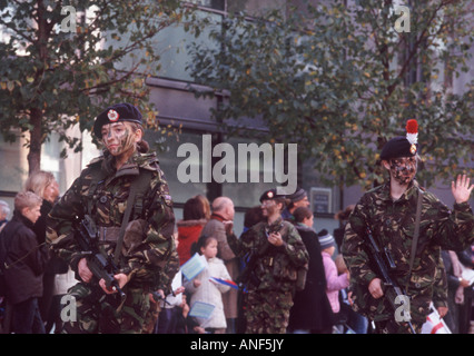 Giovani donne militari delle forze armate britanniche in camoflage fatiche e faccia vernice con armi automatiche, Londra Foto Stock