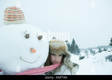 Teen girl sciarpa di condivisione con pupazzo di neve Foto Stock