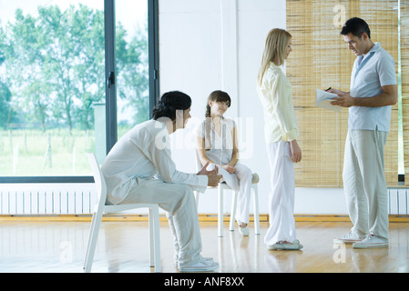 Uomo porta la terapia di gruppo sessione, guardando il notebook, parlando di donna Foto Stock